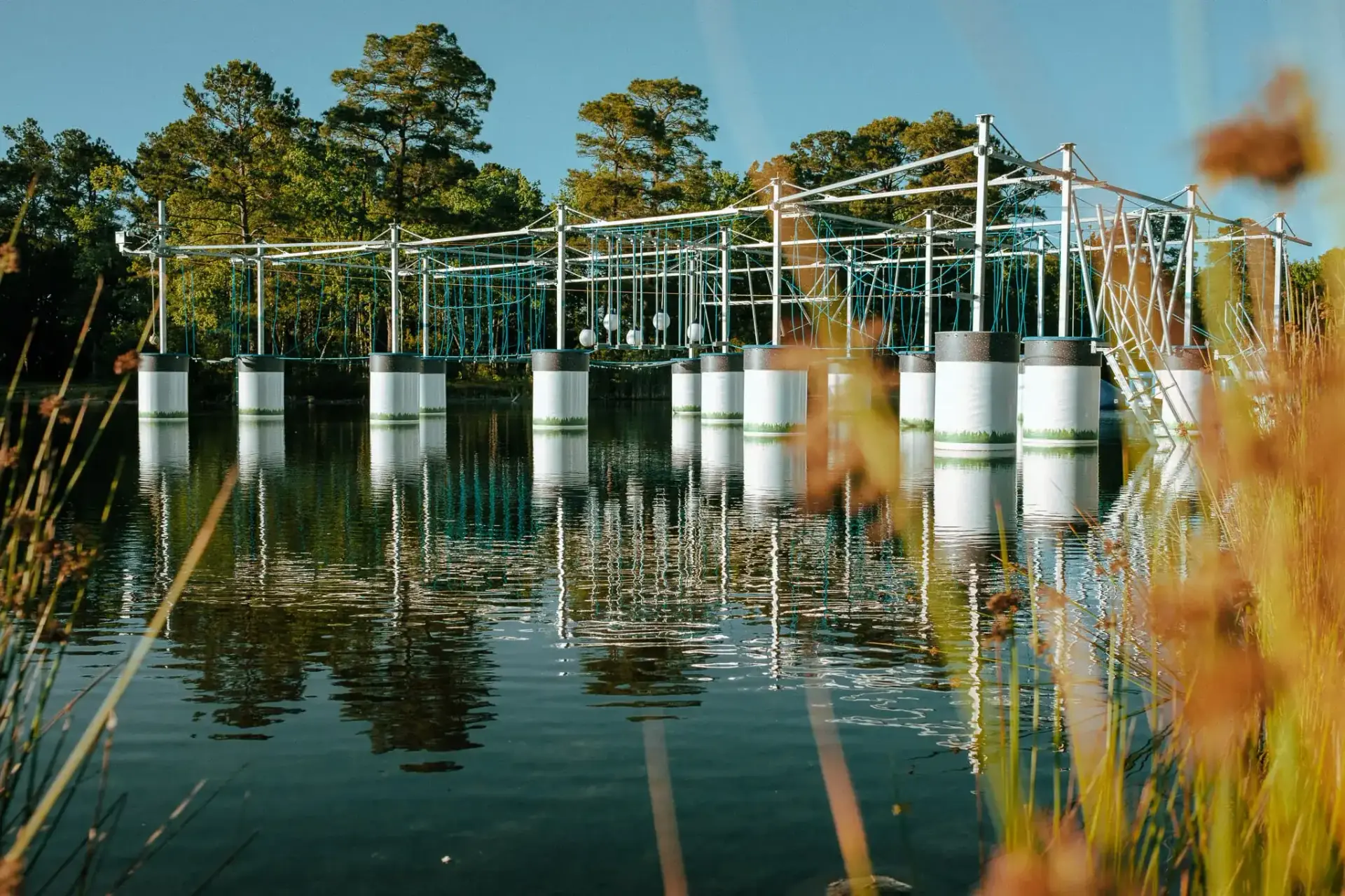 Adventure seekers climbing on America's first above-water floating ropes course with zipline at Charleston Aqua Park Johns Island SC