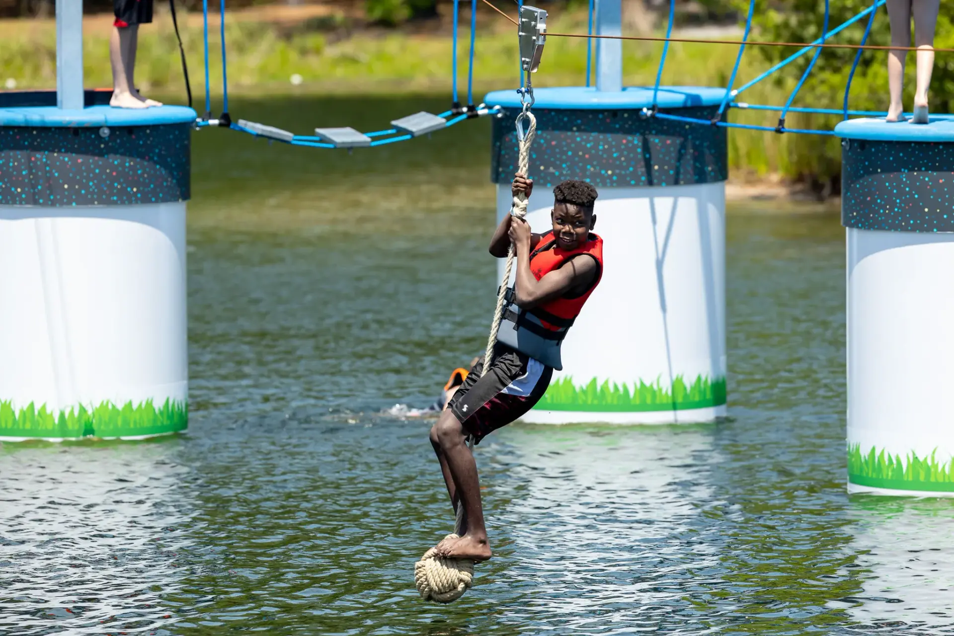 Guest navigating balance obstacles on the above-water ropes course